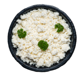 A bowl of crumbled white cheese garnished with parsley.