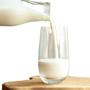 Milk being poured into a glass on a wooden surface.
